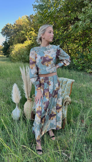 Woman in field with pampas grass and chair. Wearing a two piece dress outfit